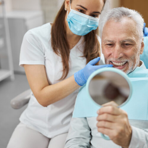 Elderly,Man,And,His,Young,Female,Dentist,Smiling,While,Looking Elderly,Man,And,His,Young,Female,Dentist,Smiling,While,Looking